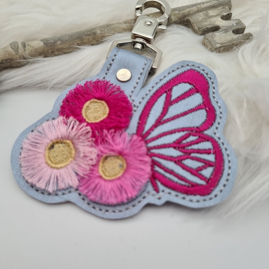 Taschenanhänger / Taschenbaumler Schmetterling mit Blumen grau/pink
